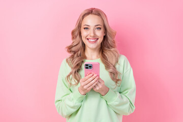 Portrait of cheerful young blogging lady holding case apple iphone device modern interface update isolated on pink color background