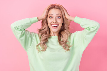 Photo portrait of crazy emotions reaction surprise funny girl hands head wow omg wear green pullover isolated on pink color background