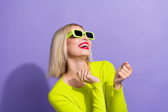 Photo of overjoyed girl wear stylish yellow shirt in glasses look empty space screm yeah win bet isolated on violet color background