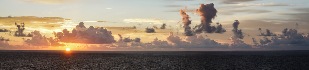 Dramatic cloud sky during sunrise/sunset over the North Atlantic Ocean and Caribean Sea looks like...