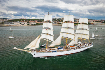 Aerial drone view of tall ships with sails sailing in Tagus river towards the Atlantic ocean in...