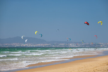 Kiteboarding kitesurfing kiteboarder kitesurfer kites on the Atlantic ocean beach at Fonte da Telha beach, Costa da Caparica, Portugal