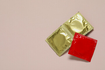 Condom packages on light pink background, flat lay and space for text. Safe sex