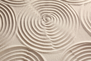 Fototapeta na wymiar Beautiful spirals on sand, above view. Zen garden