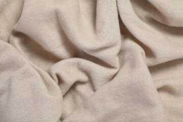 Texture of beige blanket as background, top view
