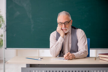 Old male teacher in the classroom