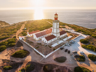 Aerial drone view of lighthouse on Cabo Espichel cape Espichel on Atlantic ocean at sunset....