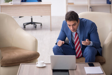 Young male employee sitting in the office