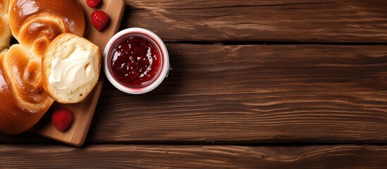 Top view of wooden background with brioche bread butter and jam on breakfast table