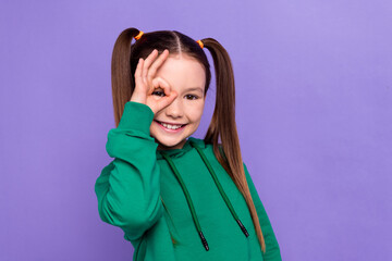 Photo of cute small funny positive daughter cover her eye showing okey gesture playing joking...