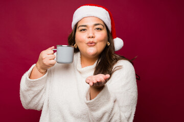 Attractive fat woman enjoying hot chocolate for christmas