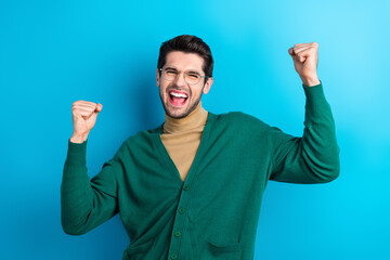 Photo of satisfied delighted person raise fists luck attainment shout yeah isolated on blue color...
