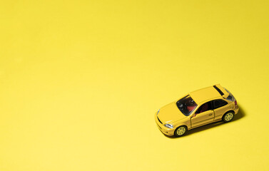 Yellow toy car isolated on yellow background. After some edits.