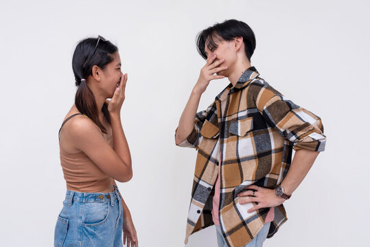 Two college students having a casual lighthearted conversation. One Filipina lady and one chinese guy telling jokes. Isolated on a white background.