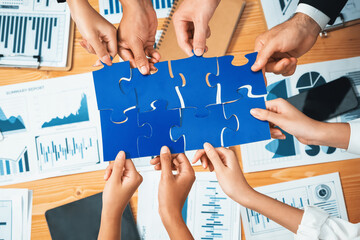 Multiethnic business people holding jigsaw pieces and merge them together as effective solution...