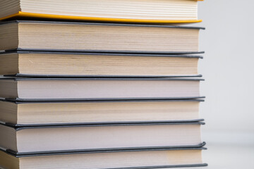 Stack of books on a white background. One book is yellow. Book reading and learning concept.