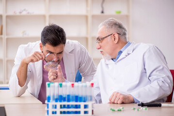 Fototapeta premium Two male chemists working at the lab