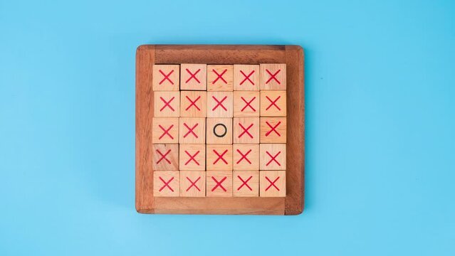 Stop motion animation of wooden game board tic-tac-toe. Turning of the letters X-O and middle one different from each other on blue background.