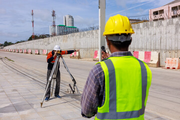 engineer use theodolite equipment working on construction site for route surveying
