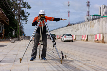 engineer use theodolite equipment working on construction site for route surveying