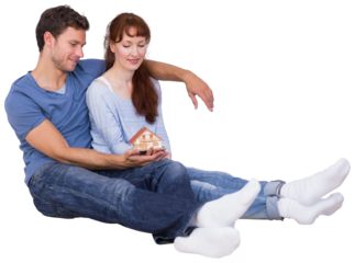 Digital png photo of happy caucasian couple holding mini house on transparent background