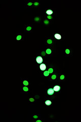 Green light, bokeh and glow on dark background isolated on a mockup space. Blur, black backdrop and defocused shine, sparkle or glitter at night for Christmas, holiday or party with magic color dots