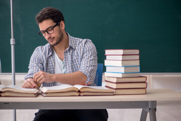 Young male teacher suffering in the classroom