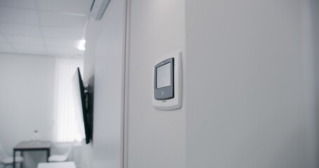 Black and white watch hanging on wall in hospital room. Electronic clock with minimalistic design...