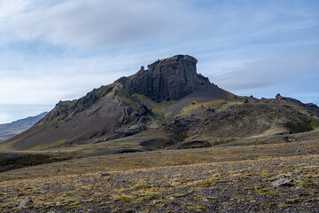 Volcano in lava fields of Fjallabak Nature Reserve in Icelandic highlands under sunny autumn cloudscape..