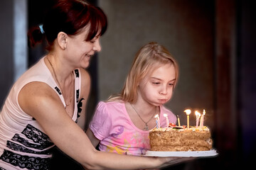 Girl trying to blow out candles on birthday cake