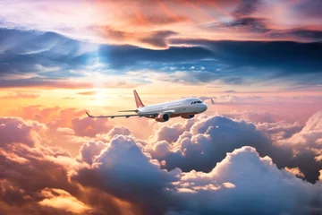 Fototapeten passenger plane flies above clouds, against background of the evening setting sun © nordroden