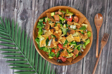 Closeup view of Healthy fattoush salad. The key ingredient in this middle eastern dish is the toasted pita bread which is mixed with healthy vegetables, herbs and a dressing made with lemon and sumac
