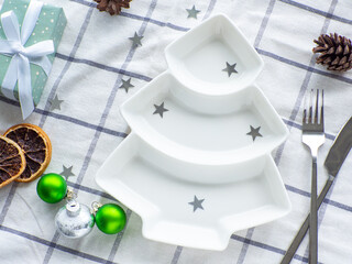 Empty christmas tree shaped white plate on towel background