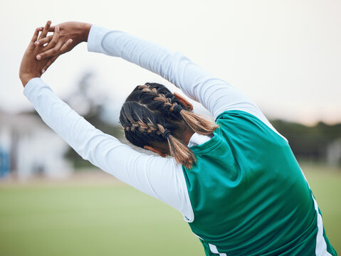 Back, stretching and a woman hockey player at the start of a game or competition outdoor for fitness. Sports, exercise and warm up with an athlete getting ready for a training workout on a field