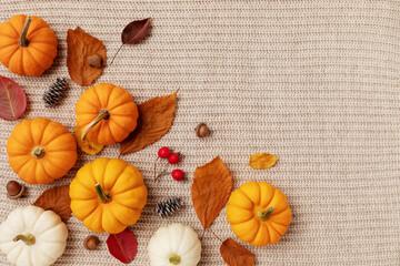 Obraz na płótnie Canvas Happy Thanksgiving composition from autumn foliage, pumpkins and fall decorations on knitted woolen background top view. Cozy and warm concept of harvest, autumn holidays and still life. .