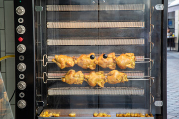 chicken on spit cook stack of grilled chicken on a skewer fried in butcher shop commercial oven - obrazy, fototapety, plakaty