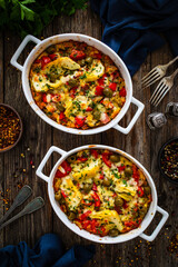 Bread casserole with mozzarella cheese, tomatoes, green olives, artichokes and scrambled eggs on...