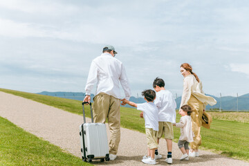 スーツケースを持って家族旅行にいく家族・ファミリー
