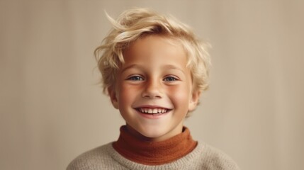 A blond boy smiles against a light beige background.