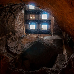 Botola per punto luce dentro un tunnel in una catacomba - obrazy, fototapety, plakaty