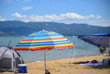 Beach umbrellas and tents at Pope Beach on a sunny summer day. South Lake Tahoe.