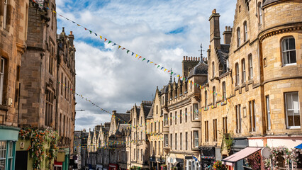 Cockburn shopping street with colorful shops and old stone buildings in Edinburgh, Scotland. - obrazy, fototapety, plakaty