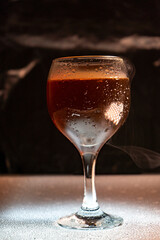 Smoky cocktail in a restaurant and a dark black background