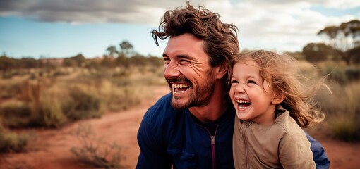 a young girl and an his father are laughing in a field