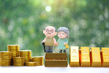 Mutual fund,Love couple senior on gold bar and stack of gold coin money on natural green...