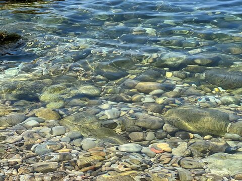 Stones pebbles in transparent sea water.