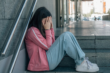 teenager girl sad and crying on the street stairs