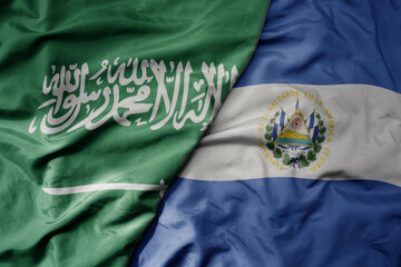 big waving realistic national colorful flag of saudi arabia and national flag of el salvador .