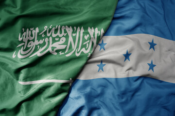 big waving realistic national colorful flag of saudi arabia and national flag of honduras .