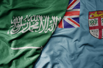 big waving realistic national colorful flag of saudi arabia and national flag of Fiji .